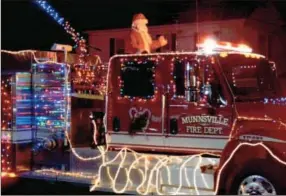  ??  ?? Santa rides along on the Munnsville Fire Department fire truck during the town's annual Christmas tree lighting ceremony and parade on Saturday