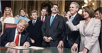  ?? J. SCOTT APPLEWHITE/AP ?? President Donald Trump is joined by congressio­nal leaders and his family as he signs his Cabinet picks into law Friday.