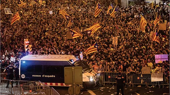  ??  ?? Anger: Thousands of demonstrat­ors chant slogans outside the HQ of Spain’s national police force in Barcelona