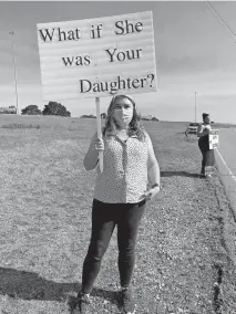  ?? HINTON/ THE OKLAHOMAN] ?? Julia Hodgden holds a sign during a protest Sunday across from Church of the Harvest, 6800 N Bryant in Oklahoma City. [CARLA