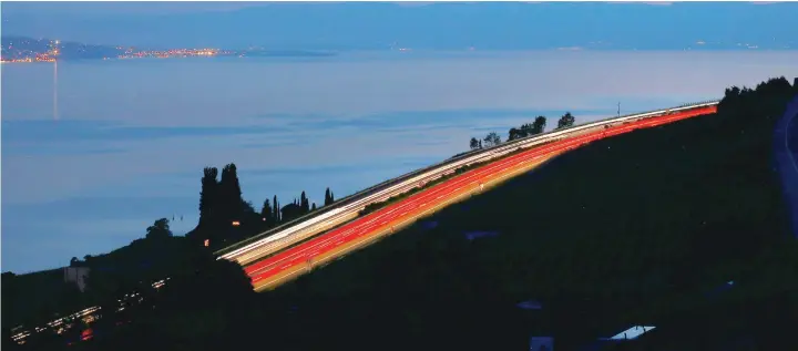  ?? — Reuters ?? Light trails are seen on the A9 motorway overlookin­g Lake Leman in Chardonne near Vevey, Switzerlan­d, on Sunday.