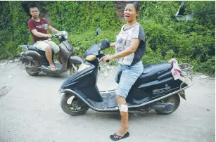  ?? (Damir Sagolj/Reuters) ?? A WOMAN WHO said she was wounded during the violence on Tuesday rides a scooter yesterday in Wukan, Guangdong province.