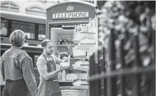  ??  ?? Spier, owner of Spier Salads, fills a customer order at his converted red telephone box in Bloomsbury Square in London on Aug 3.