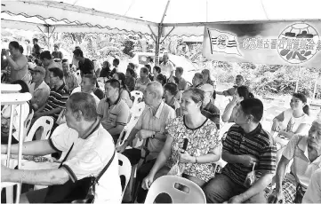  ??  ?? Recipients wait for their turn to receive angpows and festive goodies.