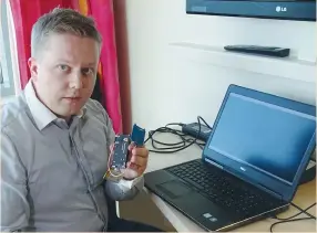  ?? (Attila Cser/Reuters) ?? F-SECURE RESEARCHER Timo Hirvonen shows a device that is able to create a master key out of a single hotel key card in Helsinki last week.