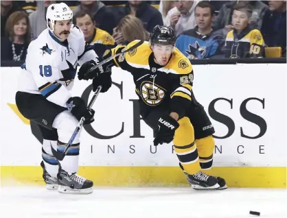  ??  ?? BOSTON: Mike Brown #18 of the San Jose Sharks defends Brad Marchand #63 of the Boston Bruins during the third period at TD Garden on November 17, 2015 in Boston, Massachuse­tts. The Sharks defeat the Bruins 5-4. — AFP