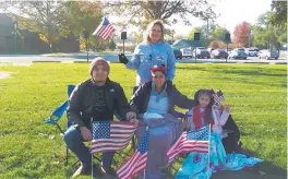  ?? SUE ELLEN ROSS/POST-TRIBUNE PHOTOS ?? Maria Becerra, of Hammond, and her children remembered to bring their American flags to the Veterans Appreciati­on Day parade. Seated are Adrian Robles, from left, Damaris Robles and Reyna Becerra.