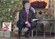  ?? CAROLYN KASTER/AP ?? President Donald Trump speaks on the phone with children as they track Santa’s movements on Christmas Eve. The president spent the holiday at his Mar-a-Lago estate in Palm Beach, Florida.