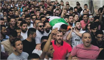  ?? AP ?? Palestinia­ns during the funeral of Aisha Al Rawbi, 47, in the West Bank village of Biddya on Saturday. She was struck on the head by a stone thrown at her car by Israeli settlers
