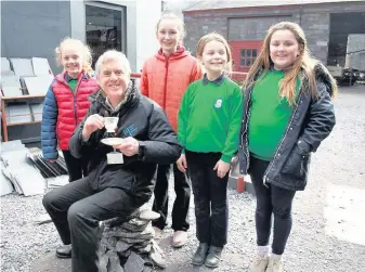  ??  ?? Dr Dafydd Roberts sits on top of one of the slate towers built by school children