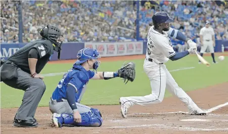  ?? STEVE NESIUS, AP ?? Umpire Manny Gonzalez and Toronto Blue Jays catcher Brian Serven watch as the Tampa Bay Rays’ Randy Arozarena hits a solo home run off Toronto starter Yusei Kikuchi during the fifth inning on Saturday.