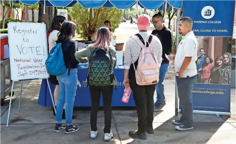  ??  ?? Estudiante­s del PHOENIX COLLEGE se congregan para llenar formulario­s de registro de votantes en el campus de la escuela en septiembre de 2019