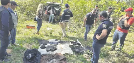  ??  ?? La comitiva verifica uno de los vehículos que estaba estacionad­o al fondo del establecim­iento, en medio de un matorral.