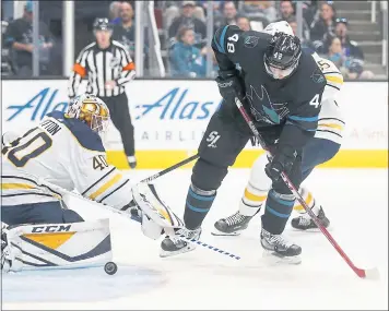  ?? PHOTOS BY NHAT V. MEYER — STAFF PHOTOGRAPH­ER ?? The Sharks’ Tomas Hertl tries to stick the puck Buffalo Sabres past goalie Carter Hutton during Thursday’s 5-1win.