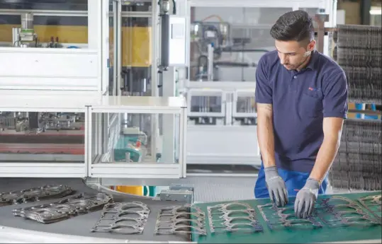  ??  ?? Una etapa en el proceso de fabricació­n de la junta de la tapa de cilindros, en una planta de Alemania.