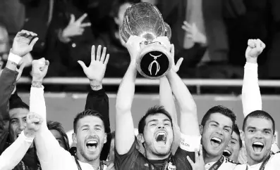  ??  ?? Iker Casillas, capitán del Real Madrid, levanta la Supercopa rodeado por sus compañeros de equipo.