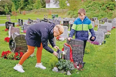  ??  ?? Isac og mammaen har hengt opp Liverpool-skjerf på graven til pappaen.