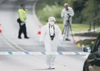  ??  ?? Police and forensic investigat­ors at the scene of the crash