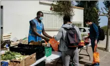  ??  ?? Un bénévole, lui-même étudiant, sert des étudiants venus chercher leur panier