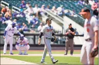  ?? Kathy Willens / Associated Press ?? Baltimore Orioles starting pitcher Matt Harvey, center, looks to the outfield with a Mets runner on third during the fifth inning on Wednesday in New York. Harvey allowed seven earned runs in 41⁄3 innings against his former team.