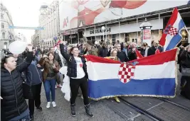  ?? AP ?? People march down a street during a protest against vaccinatio­n and coronaviru­s measures in Zagreb, Croatia, on Saturday. Earlier this month the authoritie­s introduced more restrictiv­e measures to fight the surge of coronaviru­s infections in the country.