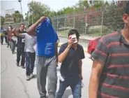  ?? AP PHOTO/EMILIO ESPEJEL ?? Migrants return to Mexico on Wednesday using the Puerta Mexico bridge that crosses the Rio Grande river in Matamoros, Mexico, on the border with Brownsvill­e, Texas.