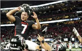  ?? JOHN BAZEMORE — THE ASSOCIATED PRESS ?? Atlanta Falcons place kicker Younghoe Koo is congratula­ted by teammates after kicking a field goal in overtime to defeat the Carolina Panthers 37-34 on Sunday in Atlanta.