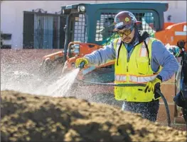  ?? FRANCINE ORR Los Angeles Times ?? A WORKER sprays water on a pile of contaminat­ed soil in November as part of a lead remediatio­n project near the former Exide battery recycling plant in Vernon.