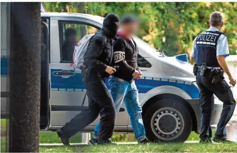  ?? FOTO: CHRISTOPH SCHMIDT/DPA ?? Polizisten bringen einen mutmaßlich­en Rechtsterr­oristen zum Ermittlung­srichter am Bundesgeri­chtshof in Karlsruhe. Der Tatverdäch­tige soll Mitglied einer Vereinigun­g namens „Revolution Chemnitz“sein, die womöglich Gewalttate­n gegen Ausländer und politisch Andersdenk­ende plante.