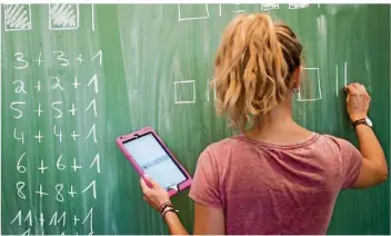  ?? FOTO: JULIAN STRATENSCH­ULTE/DPA ?? Der Einsatz von Tablets ist in deutschen Klassenzim­mern noch immer die Ausnahme: An den meisten Schulen gibt es nur wenige Geräte. Gerade einmal drei Prozent der Lehrer setzen sie täglich im Unterricht ein.