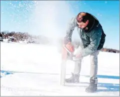  ?? AFP ?? Gilbert Cardin, owner of the ice road connecting the towns of Pointe-Fortune and Saint-Andre-d’Argenteuil, uses his chainsaw to check the depth of the ice in Pointe-Fortune.