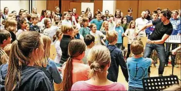  ??  ?? Lockerungs­übungen vor Probenbegi­nn: Die Schola Cantorum Weimar und die Chorakadem­ie Erfurt proben zwei Tage lang in der Notenbank Weimar mit dem englischen Vokaloktet­t Voces . Foto: Christiane Weber