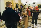  ?? MANUEL BALCE CENETA — THE ASSOCIATED PRESS FILE ?? Supporters of President Donald Trump are confronted Wednesday by U.S. Capitol Police officers outside the Senate Chamber inside the Capitol in Washington. An Arizona man seen in photos and video wearing a fur hat with horns was also charged Saturday in Wednesday’s chaos. Jacob Anthony Chansley, who also goes by the name Jake Angeli, was taken into custody Saturday.