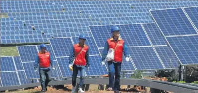  ?? SONG WEIXING / FOR CHINA DAILY ?? Employees inspect a solar-power farm in Dingyuan county, Anhui province. The National Energy Administra­tion plans to introduce a new system in the energy market to avoid wasteful investment­s and poor distributi­on of solar assets.