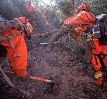  ??  ?? Près de Yucaipa, des prisonnier­s ont été appelés en renfort pour combattre les feux. PHOTO AFP