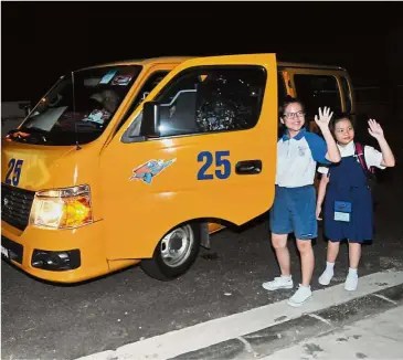  ??  ?? Early birds: Xiao Ni (right) and Xiao Ting saying goodbye to their mother as they climb into the school van to head to school in Singapore.