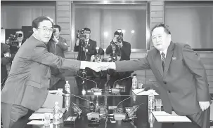  ?? — Gambar AFP ?? RUJUKAN TERBUKA: Cho (kiri) berjabat tangan dengan Ri ketika pertemuan di perkampung­an gencatan senjata Panmunjom dalam Zon Bebas Tentera semalam.