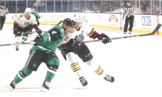  ?? ROSS DETTMAN/WOLVES ?? Wolves defenseman Nicolas Hague (right) battles Stars defenseman Joel Hanley for position as they chase the puck Wednesday at Allstate Arena.