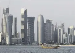  ??  ?? 0 A traditiona­l dhow floats in front of Qatar’s financial district