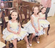  ??  ?? Amelia, 4, from left, Penelope, 6, and Seraphina, 3, smile for a photo at their adoption ceremony Thursday in Manchester.