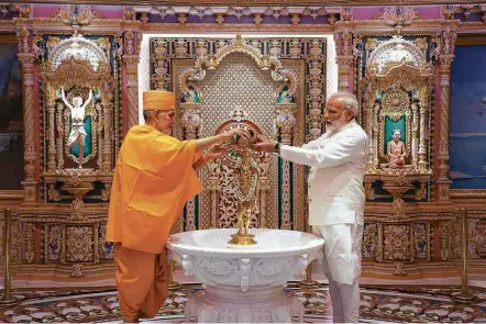  ?? Templo Akshardam - 2.nov.17/AFP ?? Premiê indiano, Narendra Modi (à dir.), faz ritual hindu no Templo Akshardam com líder espiritual M. Swami Marahaj