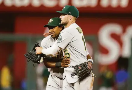  ?? Photos by Charlie Riedel / Associated Press ?? Shortstop Elvis Andrus (left), who had four hits, and right fielder Seth Brown celebrate after the A’s held off the Royals.