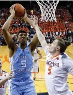  ?? AP PHOTO ?? ALTERING THE RANKS: North Carolina’s Tony Bradley shoots against Kyle Guy during No. 23 Virginia’s upset win over the No. 5 Tar Heels last night.