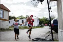  ??  ?? Jonathan Urquiza (left), 10, and his friend David Chairiz, 13, play basketball at Thrasher Lane Mobile Home Park. Although the initial move-out notice gave residents about 45 days to move out, property owner Urban Rio LLC later granted the residents’...