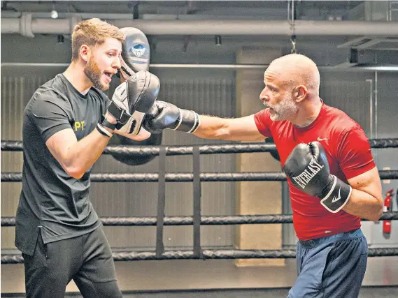  ?? ?? Sparring partners: Phil Hilton, right, with boxing trainer William White