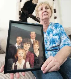  ??  ?? Irene Kavanagh holds a photo of her family with Dan On, the Vietnam boat refugee she and her late husband George sponsored.