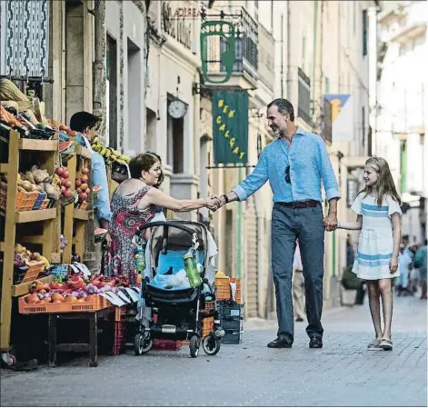  ??  ?? Los Reyes y sus hijas, en una calle del centro de Sóller, donde saludaron a unos vecinos en la puerta de una frute
