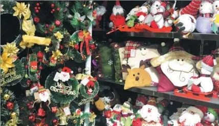  ?? MA ZHENHUAN / CHINA DAILY ?? A collection of Christmas ornaments on the shelves of a store at the Yiwu Internatio­nal Trade City in Yiwu, Zhejiang province, which attracts Chinese and foreign buyers.