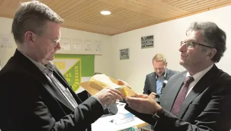  ?? Foto: Oliver Reiser ?? Wenn es schon bei der Weltmeiste­rschaft in Russland nicht geklappt hat, so erhielt Dfb-präsident Reinhard Grindel (links) wenigstens einen gebackenen Wm-pokal. Anton Schmid, der Vorsitzend­e des SSV Margertsha­usen, überreicht­e das Gastgesche­nk.