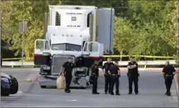  ?? ERIC GAY, THE ASSOCIATED PRESS ?? Police investigat­e the scene where a tractor-trailer packed with migrants was found outside a Walmart store in stifling summer heat. Nine people died in the horrific smuggling case.